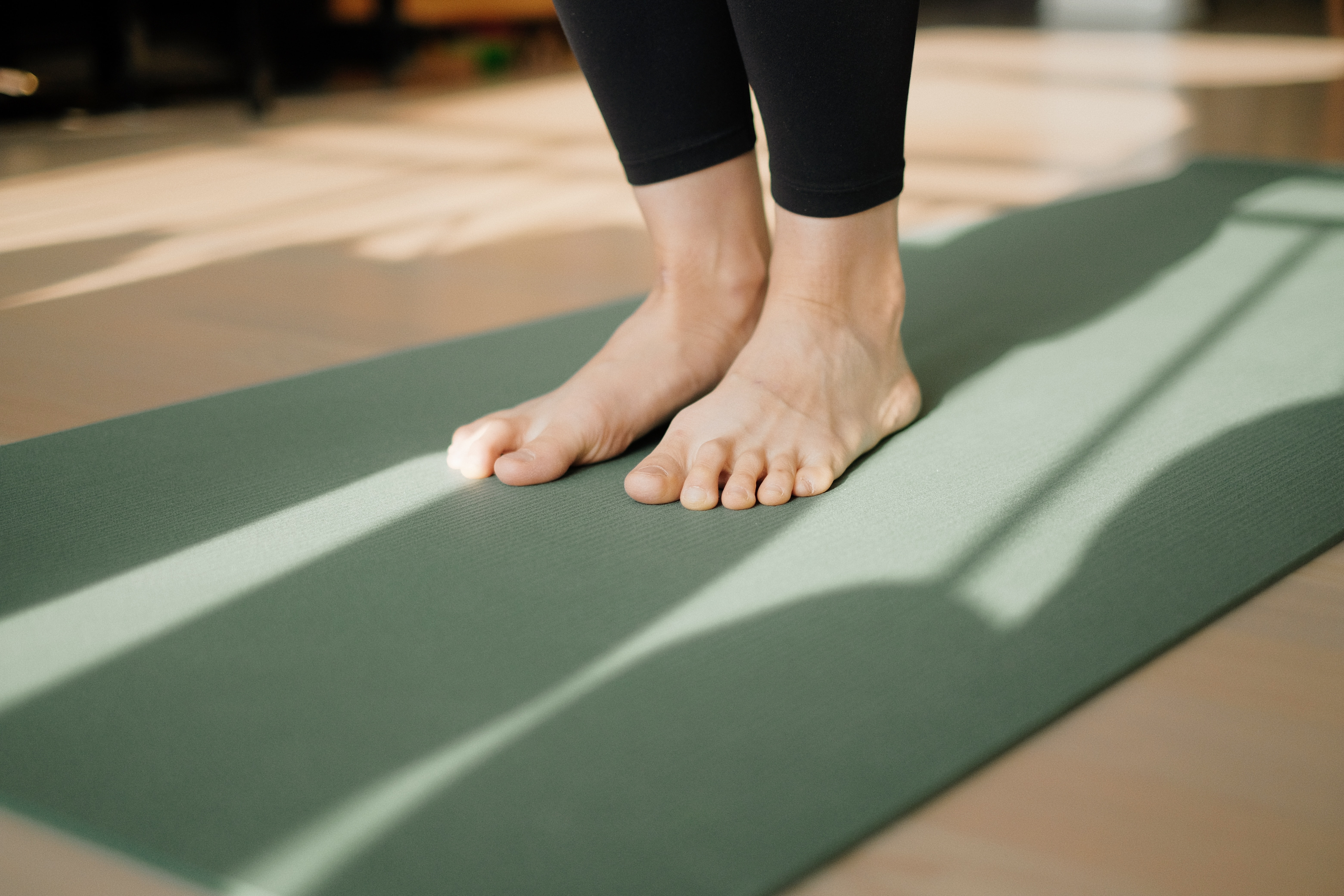 woman standing on yoga mat in yoga studio