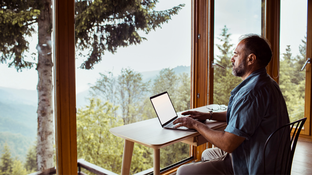 working man using yoga techniques at a desk with a beautiful view